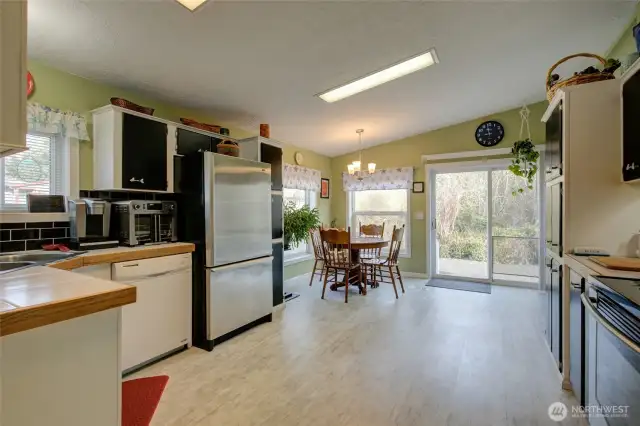 Remodeled kitchen with newer appliances, dining space, and side door.