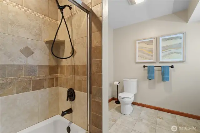 This full bathroom in the daylight basement unit also includes the laundry area