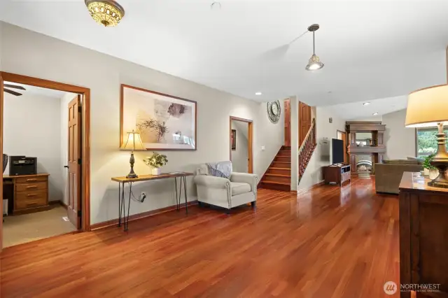 A large open area looks toward the living room and fireplace. An office is just inside the front entrance.