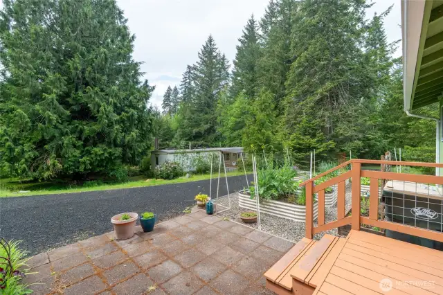 Back patio leading to established high end garden beds