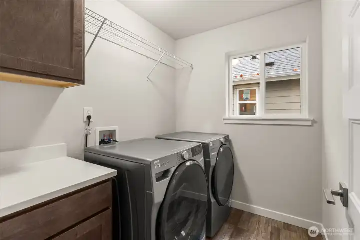 Light and bright laundry room on the second floor. Features an upper and lower cabinet plus quartz countertop.  Washer and Dryer included.