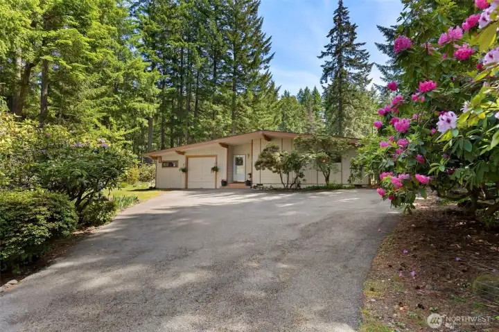 The stately private driveway leads to beautiful mature landscaping