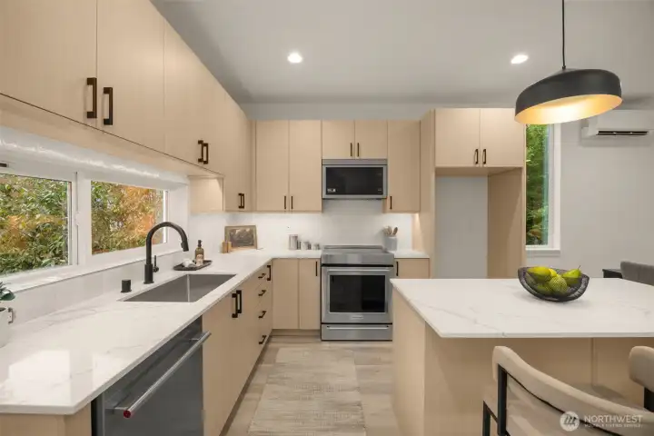 Gourmet kitchen boasting crisp white cabinetry, premium stainless steel appliances, and a spacious island. (photos are of model home, similar finishes & quality)