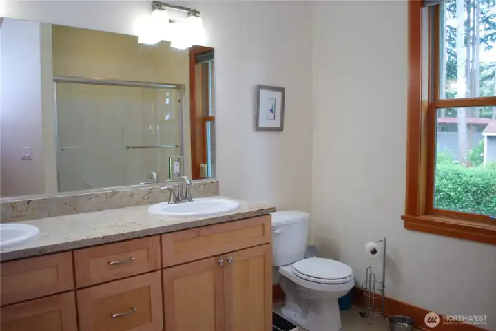 Hallway view into the main bath with granite counter tops, two sinks, full tub and shower, and glass door. Hallway view into the main bath with granite counter tops, two sinks, full tub and shower, and glass door.