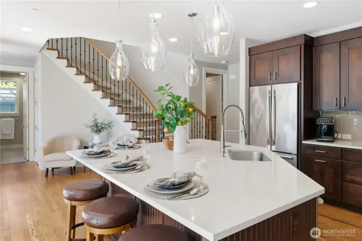 A beautiful island vantage point featuring the bridal staircase to the second floor, with a convenient 3/4 bath and generous under-stair closet just to the left