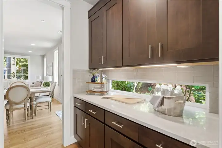 A generous butler’s pantry with elegant cabinetry and a garden-view window. Just to the left (not shown) is the large walk-in pantry, with the formal dining area visible beyond