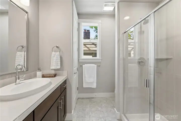 Back inside, the main-floor 3/4 bath offers a spacious shower, beautifully finished cabinetry, and a full-height closet for extra storage.  Just outside the window, the custom-built shed offers sheltered winter storage for garden furniture and more