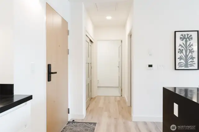 Entry hallway to stackable washer/ dryer closet, entry closet and 1/2 bath.