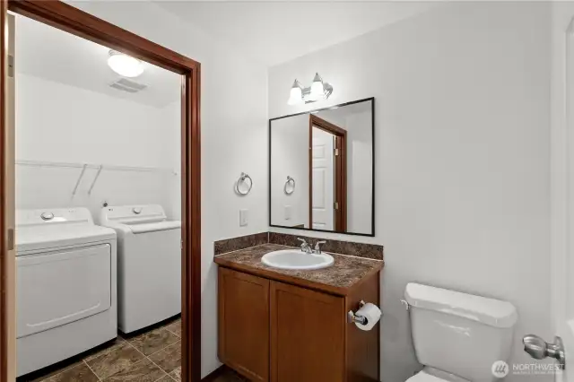 Main floor half bathroom conveniently located with a subtly connected laundry room for added functionality.
