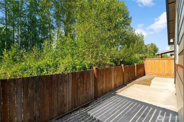 Serene backyard is fully fenced, offering privacy and cozy patio.