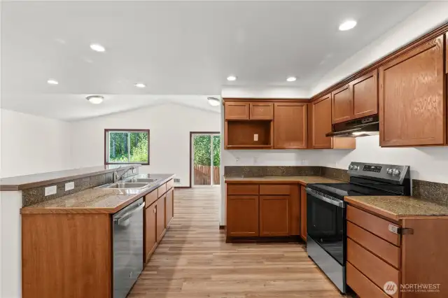 The kitchen is the heart of the home with a spacious island, recessed lighting, and new electric stove/range and dishwasher.
