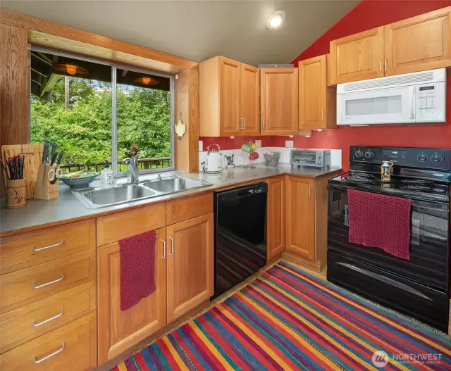 Big kitchen window overlooks the eastern entrance to the property. Plenty of nice cabinetry.