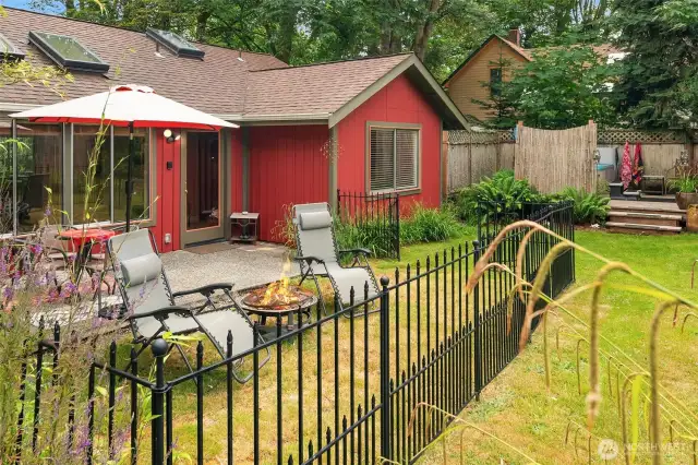 View of the back patio and enclosed yard of main home. Landscape is simple yet appealing. Easy care!