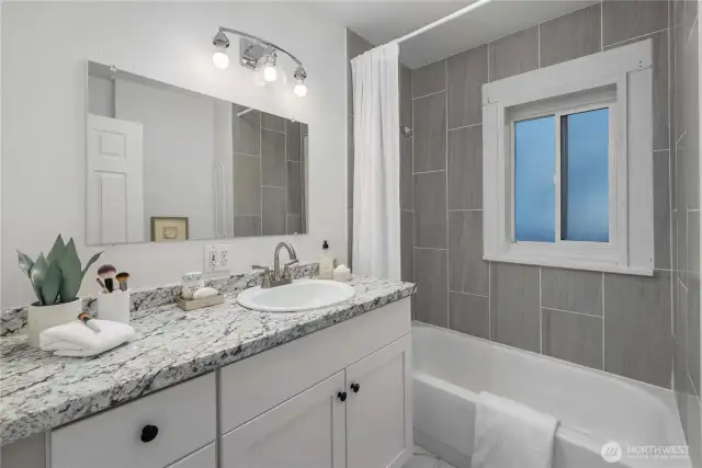 Cute bathroom and tiled tub/shower surround.