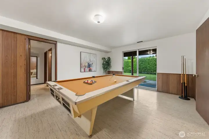 The family room opens directly to the backyard through sliding glass doors, creating a great indoor-outdoor connection. The hallway leads to two additional bedrooms and a full bathroom, offering flexible living options.