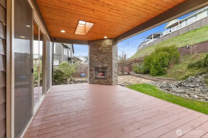 Additional view of the covered deck with skylight, fireplace, ceiling lighting and more!