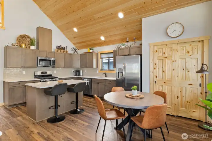 Quartz countertops, stainless steel appliances, and a generously sized pantry make this kitchen both beautiful and highly functional.