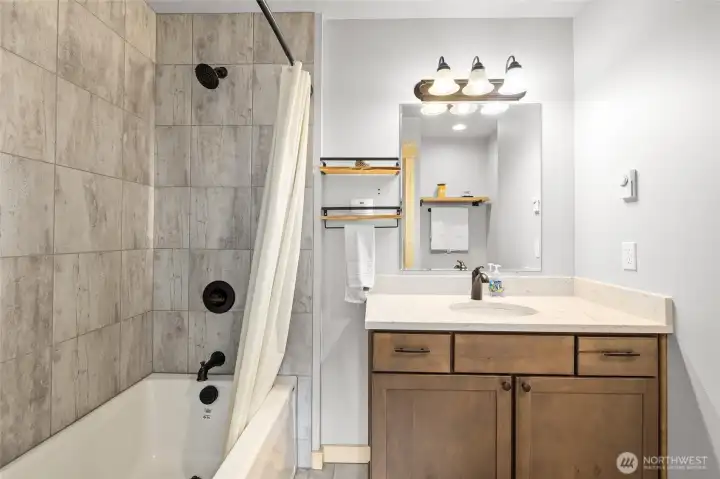 The primary ensuite offers a luxurious full-sized tub surrounded by a beautifully tiled enclosure.