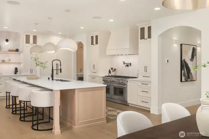 Chef’s kitchen with Thermador appliances, expansive island, custom cabinetry, and designer lighting, designed for both everyday living and entertaining.