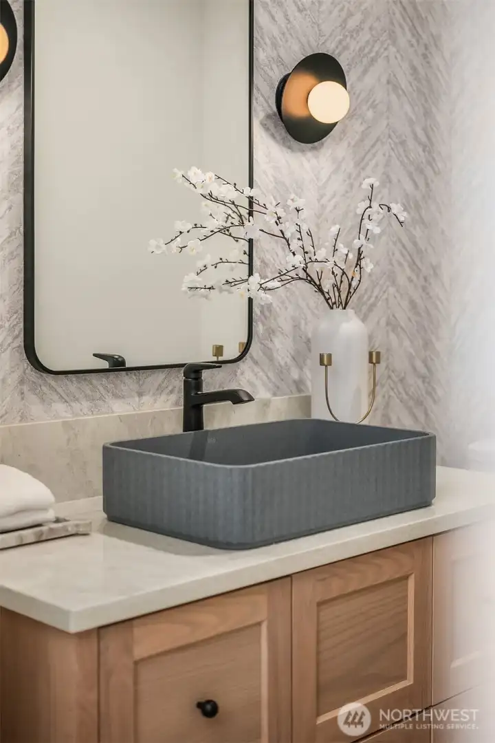 Powder room with custom vanity, statement lighting, and motion-sensor toe-kick lighting for added function and ambiance.
