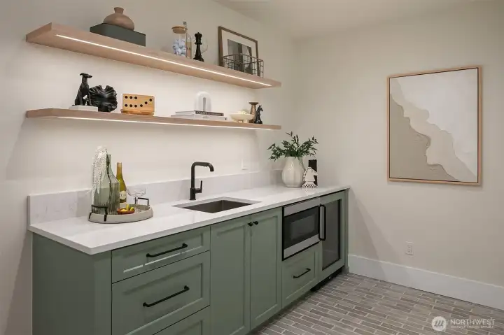 Entertaining made easy in the bonus lounge with a built-in wet bar featuring custom cabinetry, open shelving, a microwave, and a sleek beverage fridge.