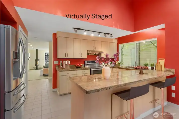 Soaring vaulted ceilings and skylights lend the kitchen an airy, expansive feel, beautifully complemented by updated stainless steel appliances and granite counters.