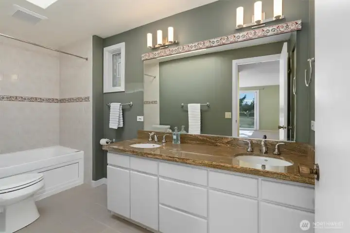 The primary bath is a genuine spa-like retreat, featuring a jetted tub and shower, dual sinks, and everything you need to begin or end the day in pure relaxation.