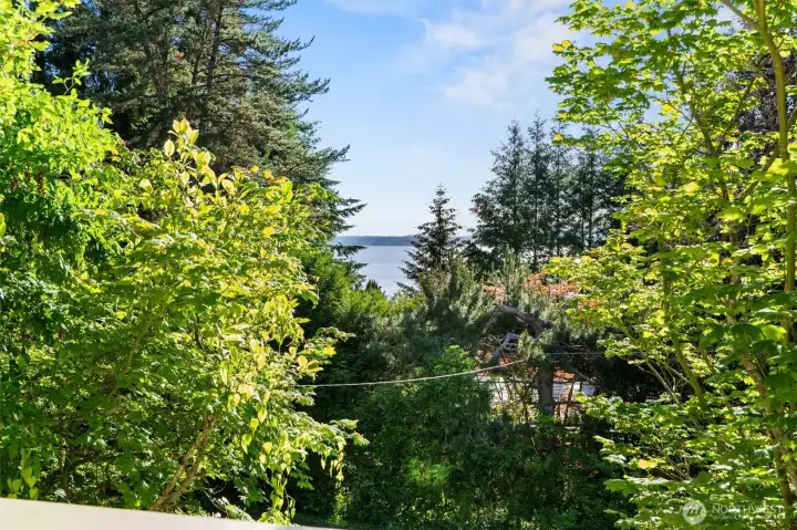 Even the lower bedroom gets in on the views — a private deck frames a charming peek-a-boo glimpse of Puget Sound that adds an unexpected and welcome surprise.