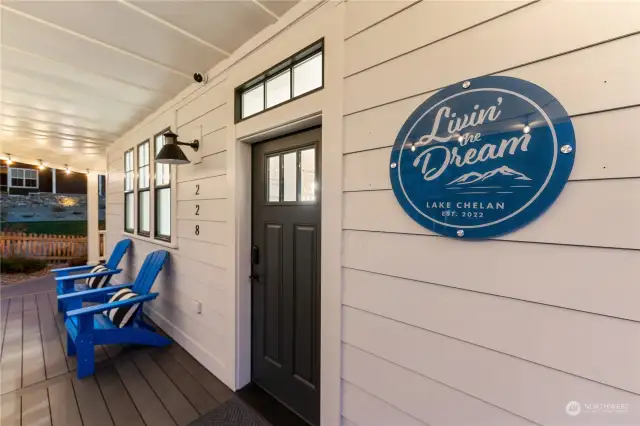 Classic covered wraparound porch & front door welcome sign.