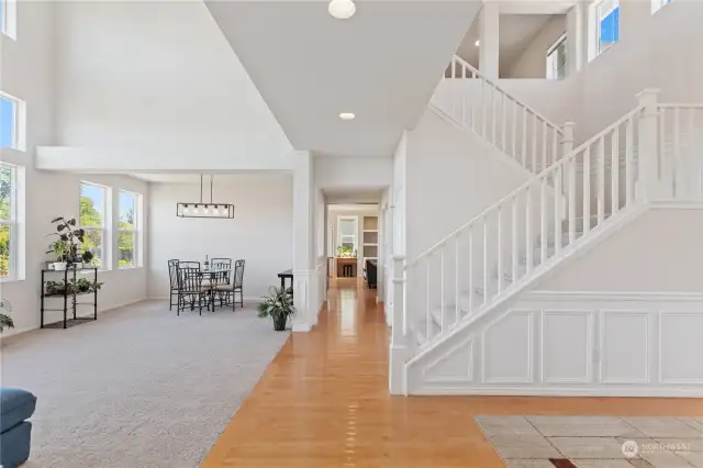 How impressive is this? Look at the high windows, the wood railing, the wood floors, beautiful chandelier, and generous space to enter....what a grand entry as you walk in to full on views of the Cascade Mountains with the wall to wall view windows.