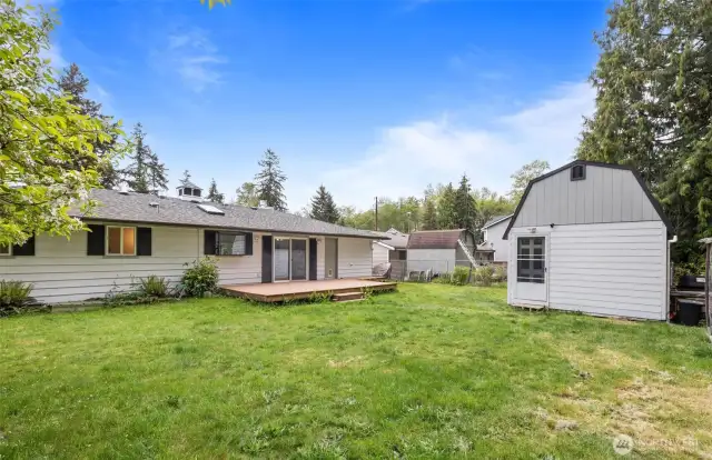 Large, level backyard with deck, shed, and compost bin