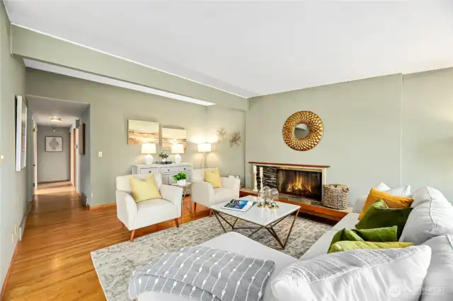A shot of the living room looking toward hallway to three bedrooms (including primary) and full bath.