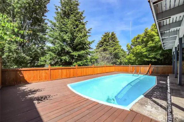 Fully-fenced pool area and deck located on private greenbelt (west) side of property.