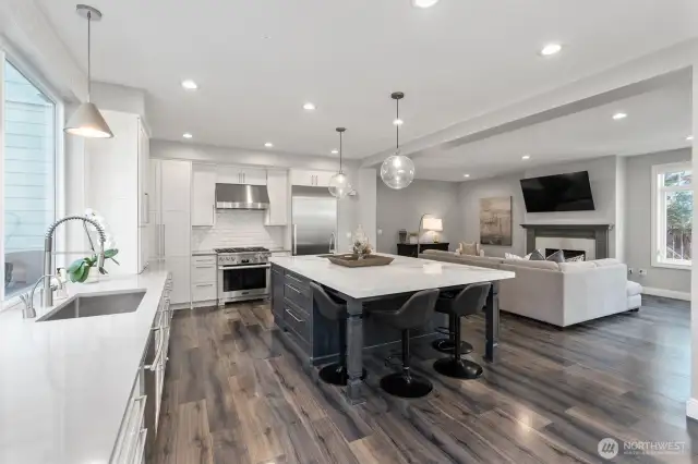 Top-tier stainless appliances, dual dishwashers, and gleaming engineered hardwoods elevate the kitchen.