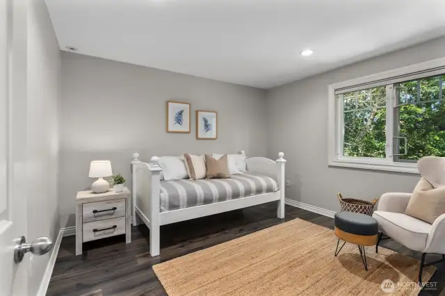 Serene upstairs bedroom with natural light and a garden-facing window.