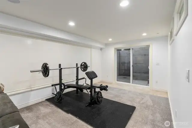 Lower-level space ideal for home workouts and gym equipment.
