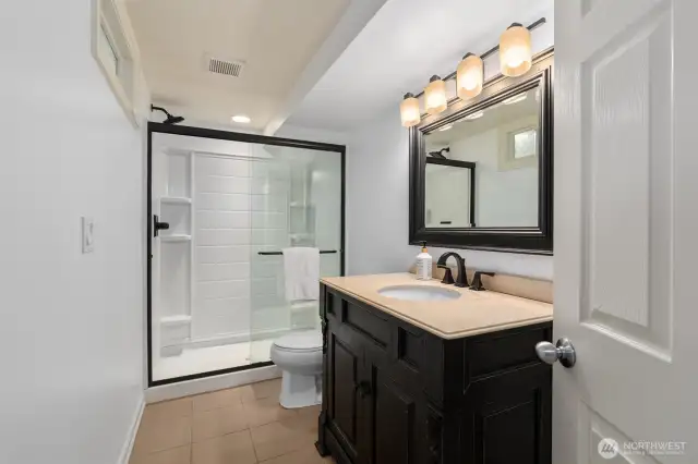 Elegant lower-level ¾ bath featuring stylish finishes and a walk-in shower—perfect for guests or added convenience.