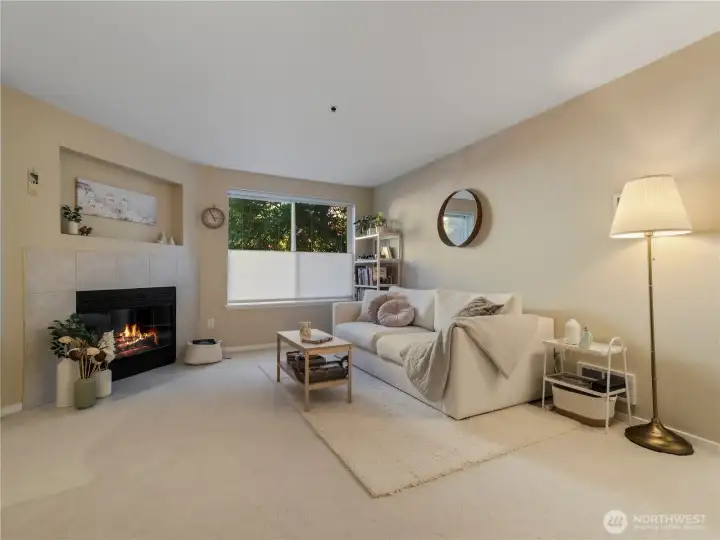 The living room features a cozy wood fireplace with tile surround.
