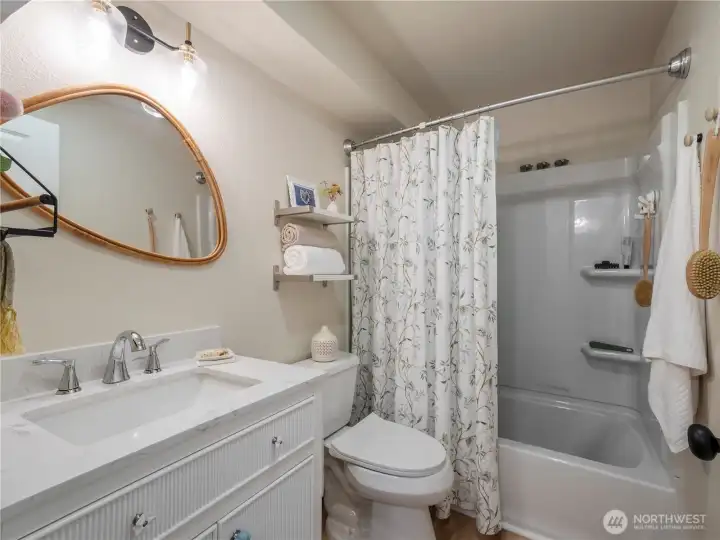 Bathroom has been completely remodeled with new flooring, vanity and shower/tub surround.