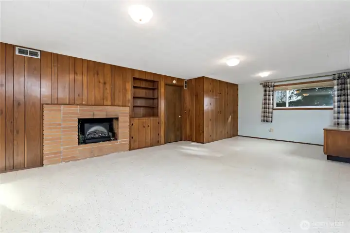Daylight basement area with fireplace, closets, built in shelves
