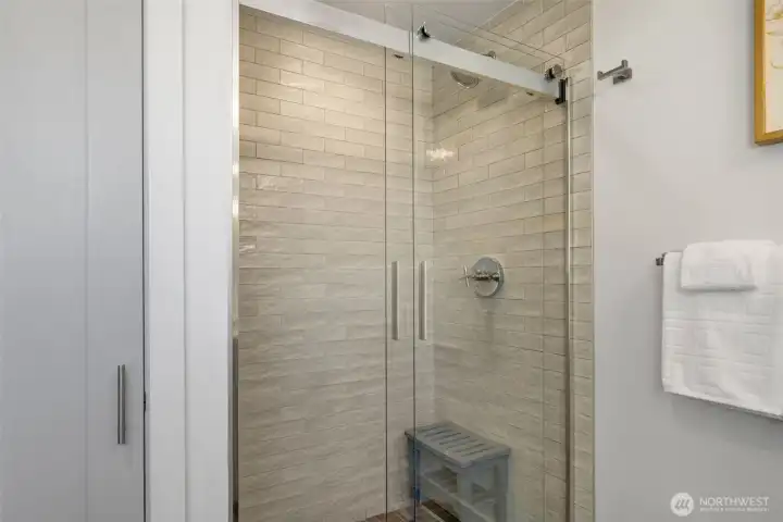 Beautiful glass encloser and floor to ceiling tile in primary bathroom
