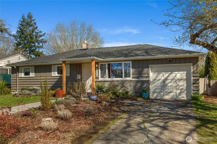 View of verdant front yard and attached garage