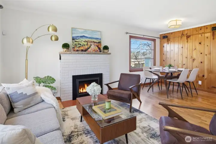 Cozy open concept with gas burning fireplace and original wood floors.