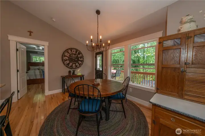 The kitchen eating nook has hardwood floors, vaulted ceiling and a door to the covered deck.