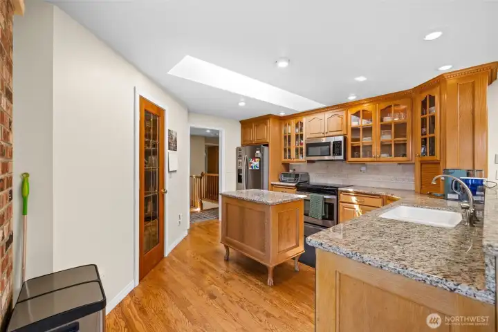 Centrally located kitchen with rich wood cabinets and walk in pantry