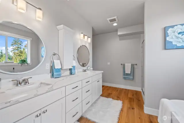 Step into a spa-like en-suite bathroom, featuring a double vanity, luxurious soaking tub, and a walk-in shower with designer tile work.