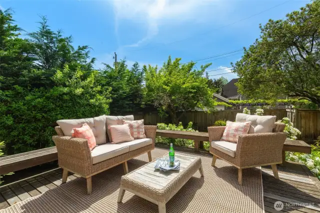 Large deck perched above the lush lawn.