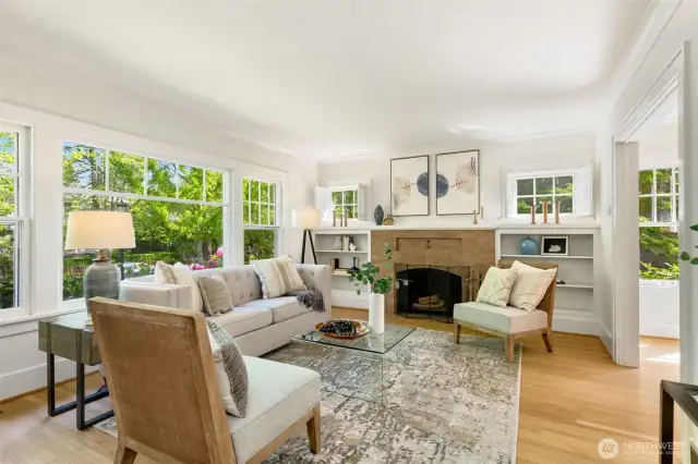 Expansive windows frame the wood burning fireplace.