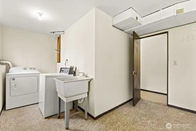 Roomy and ready to work—this utility space features a washer, dryer, deep utility sink, and space for folding, sorting, or leveling up your laundry game.