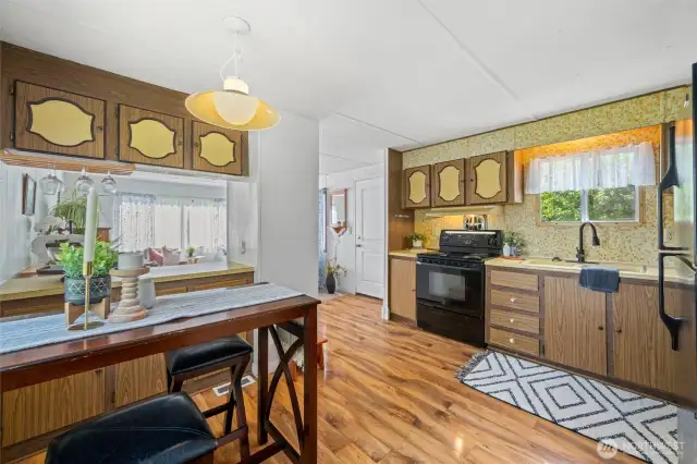 Retro-Inspired Kitchen with Dining Space- The vintage kitchen brings personality and functionality, featuring ample cabinetry, a full-size stove, and a cozy dining nook—perfect for casual meals after a day of shell hunting or paddleboarding....